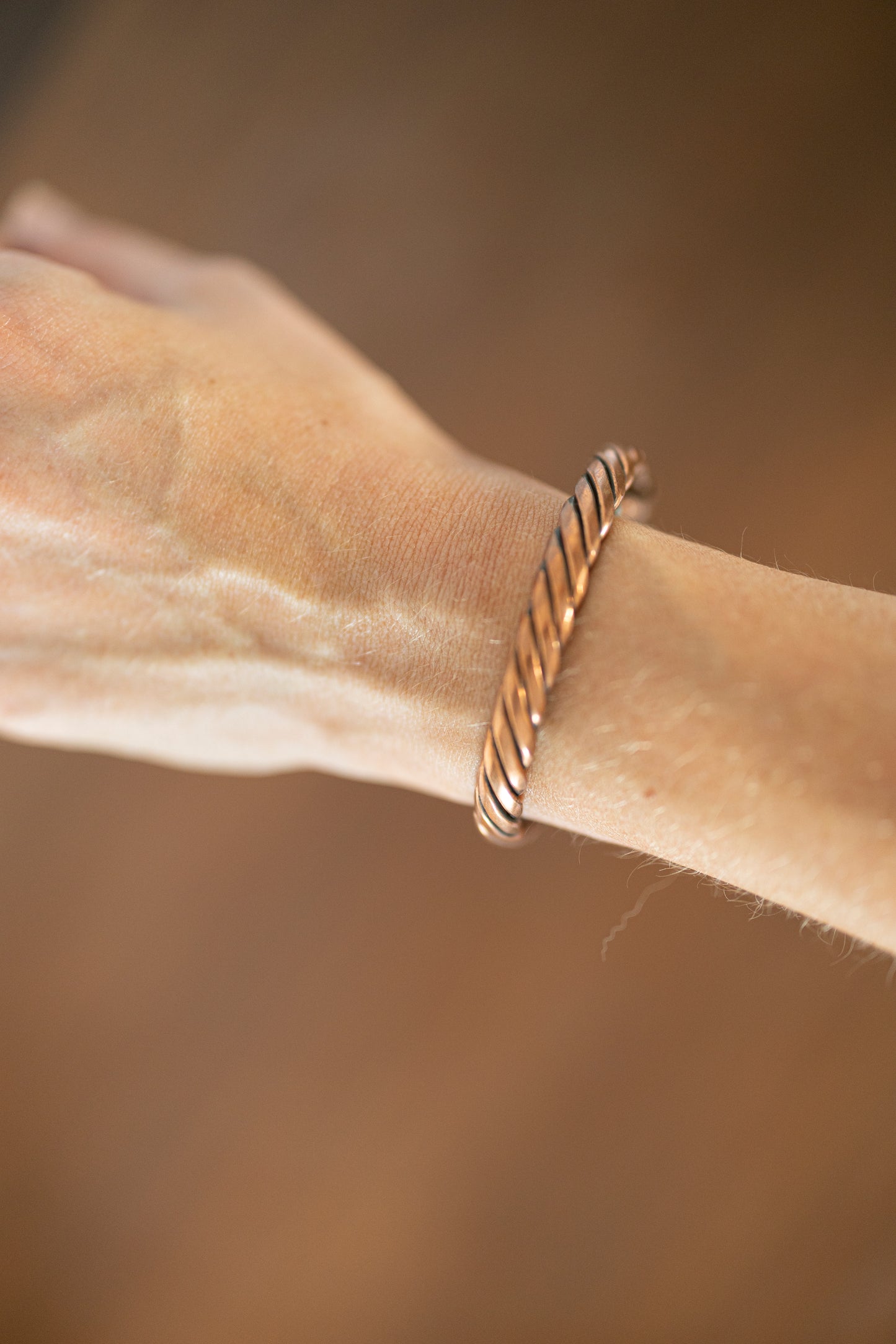Kopero Premium Kopararmband Vriden, närbild på den vridna koppartråden runt handleden