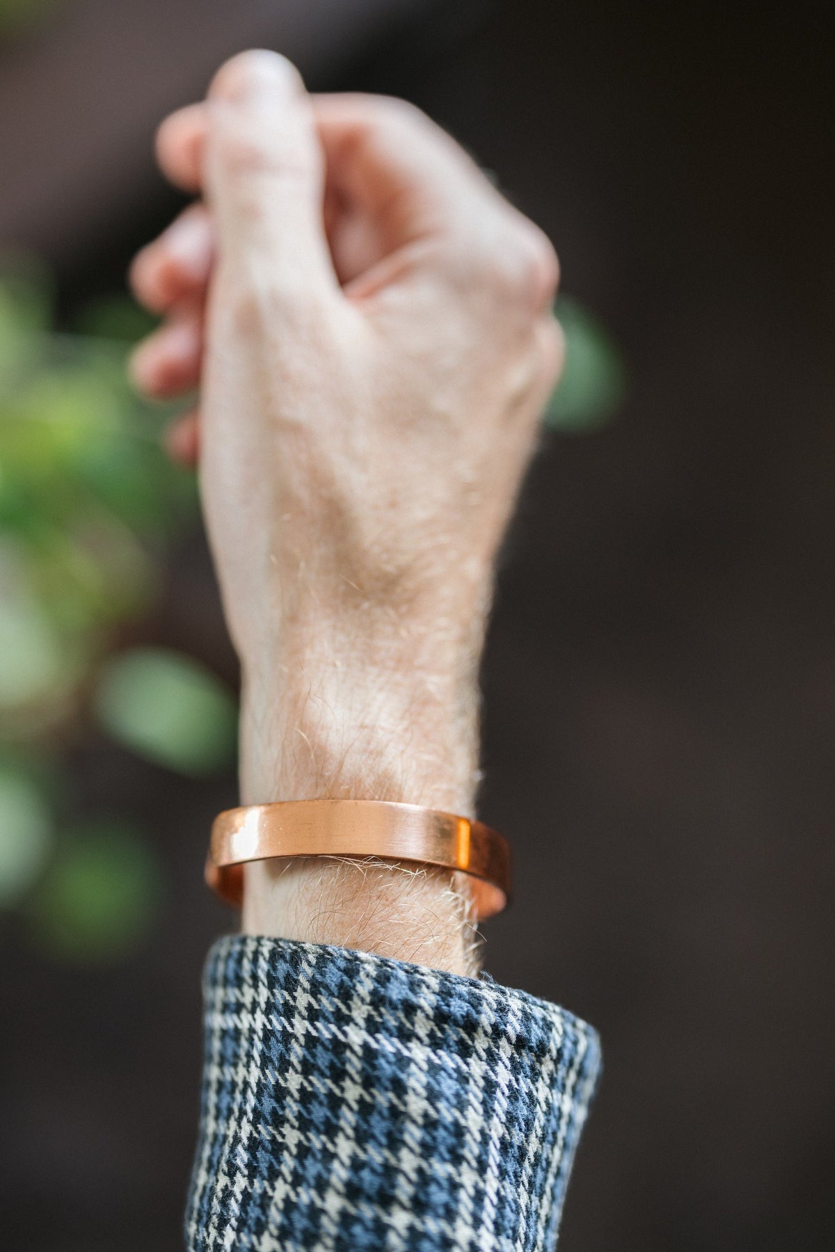 Kopero Koppararmband Slät, på handleden, med handen uppåt mot en mörk bakgrund