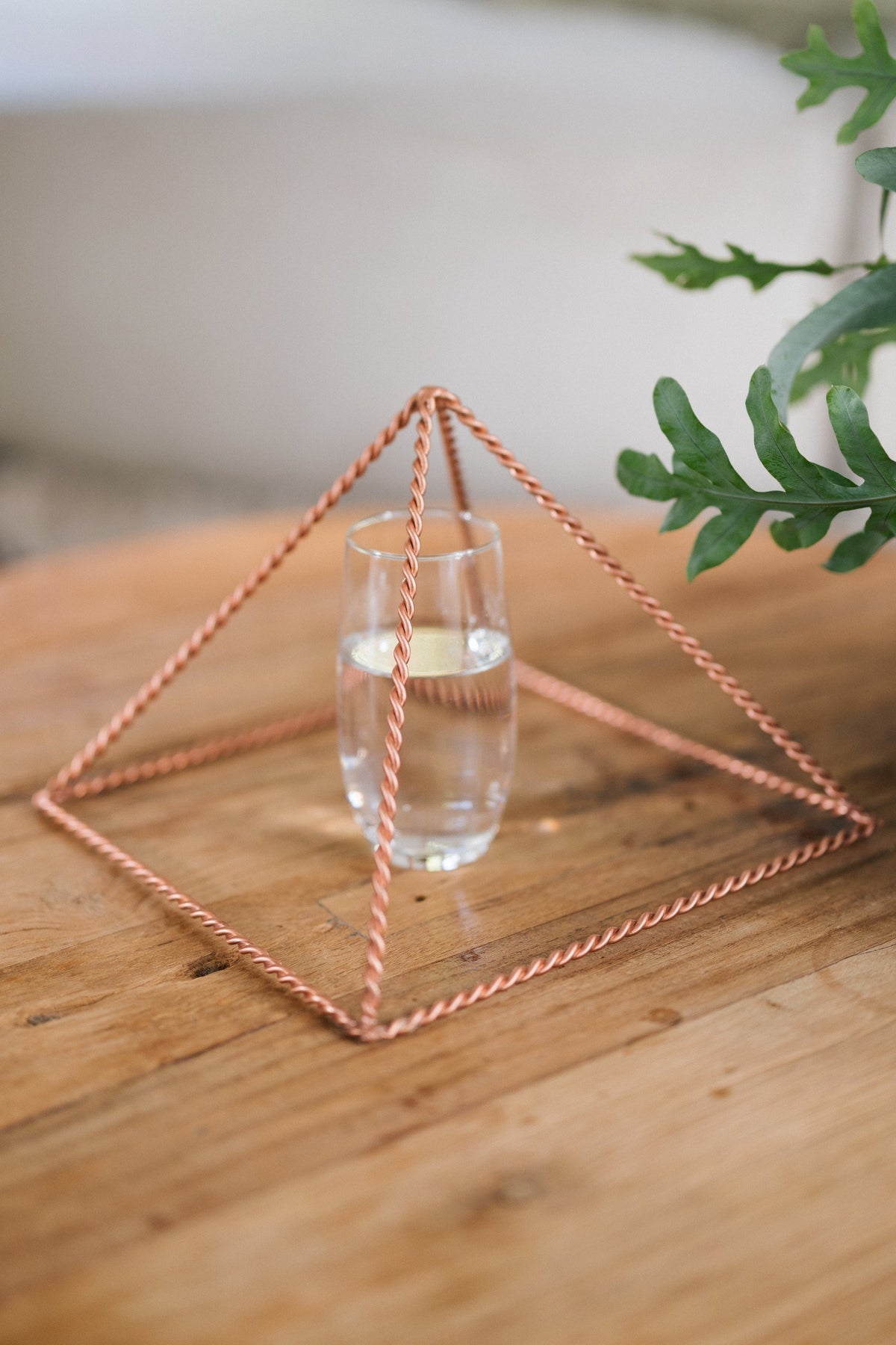 Kopero Kopparpyramid Energizer Tvinnad Stor (23,56 cm), med ett glas vatten under