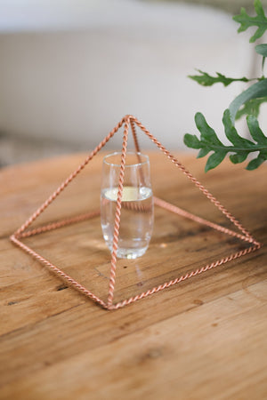 Kopero Kopparpyramid Energizer Tvinnad Stor (23,56 cm), med ett glas vatten under
