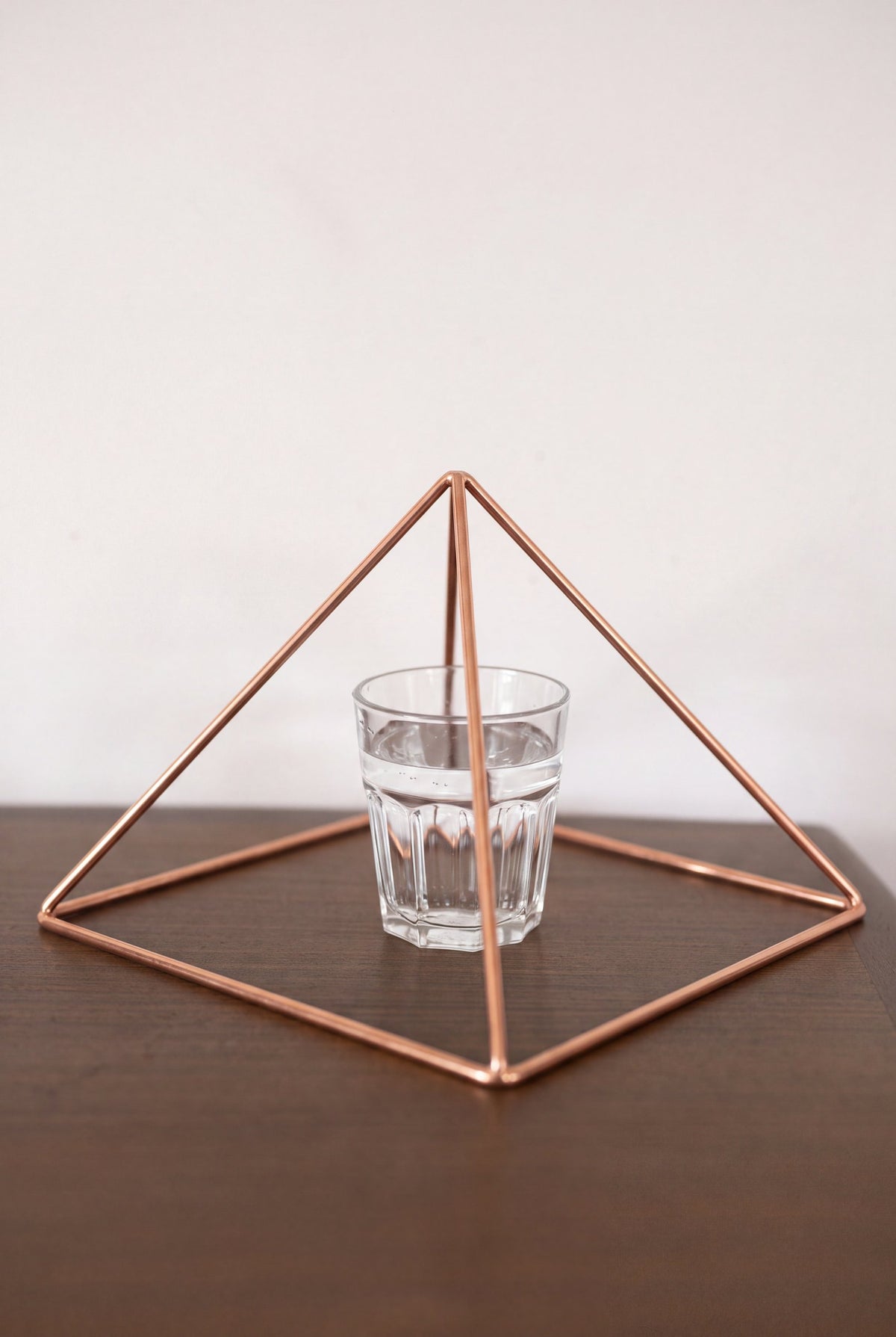 Kopero Kopparpyramid Energizer Slät Stor (23,56 cm) ovanför ett glas vatten