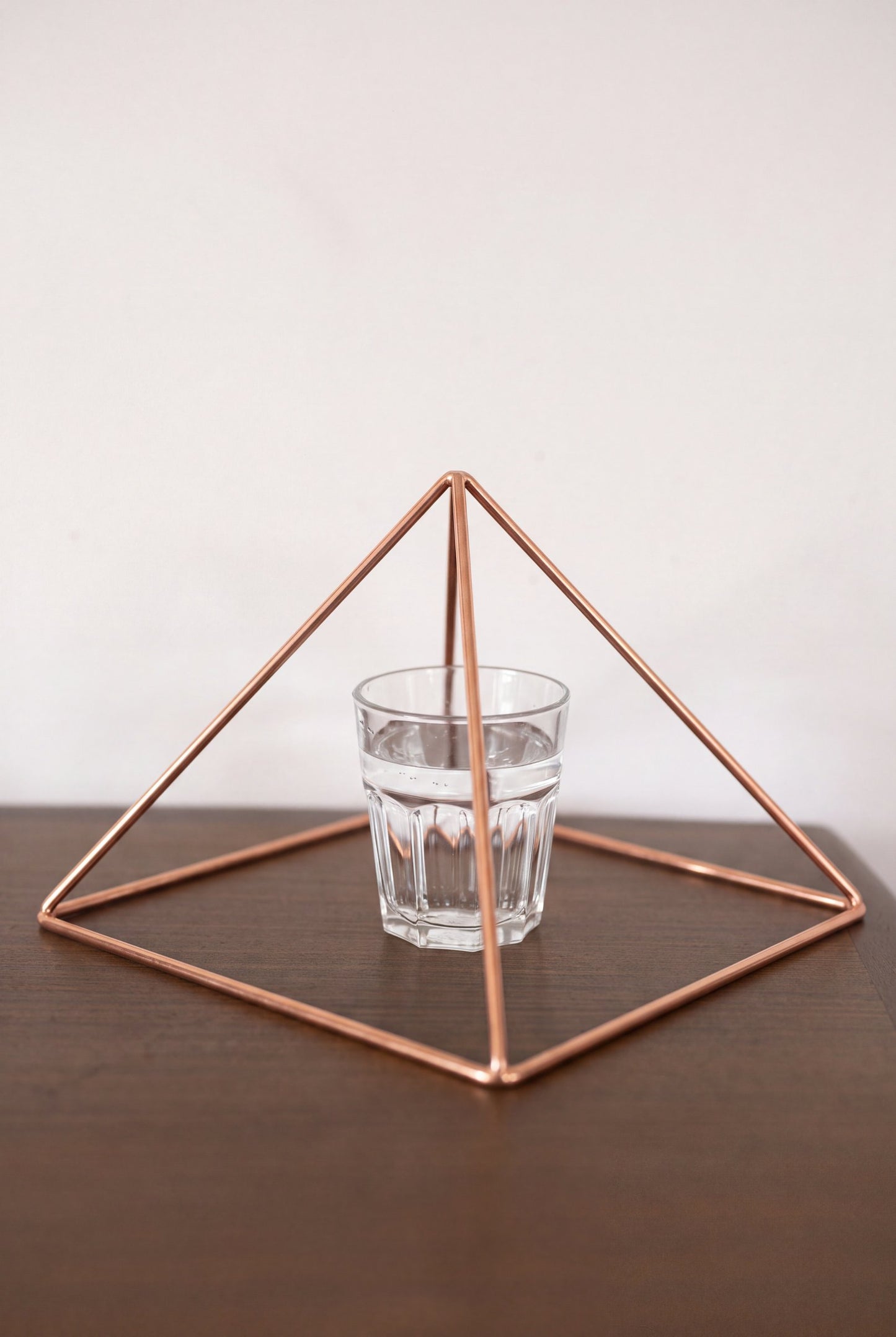 Kopero Kopparpyramid Energizer Slät Stor (23,56 cm) ovanför ett glas vatten