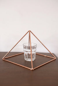 Kopero Kopparpyramid Energizer Slät Stor (23,56 cm) ovanför ett glas vatten